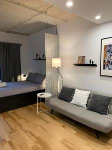 um quarto com um sofá, uma cama e uma mesa em Le Studio Picasso "parking inclus" em Cidade de Quebec