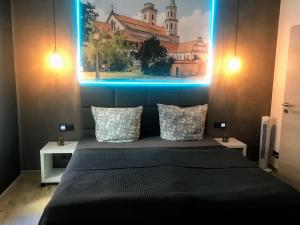 a bedroom with a bed with a painting on the wall at BUDGET APARTMENTS - SALZHAUSBLICK FERIENWOHNUNGEN - TOP INNENSTADT LAGE am SALZHAUS STADTZENTRUM mit HOTELBETTEN in Zittau