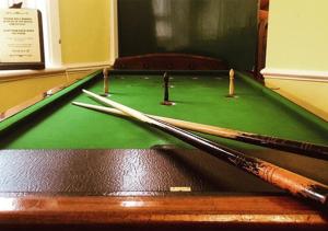 a pool table with three cue sticks on it at The Jenny Lind in Hastings