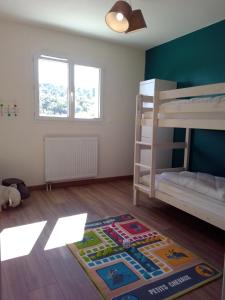Mały pokój z łóżkiem piętrowym i dywanem w obiekcie La Masquénada 85 m2, neuve, moderne, confort avec grand garage w mieście Cublac