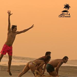 a group of people playing frisbee on the beach at Coco House - Playa La Barra in Buenaventura