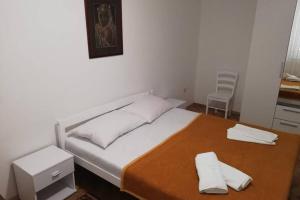 Banjol的住宿－RIBARIĆ，一间卧室配有一张床,上面有两条毛巾