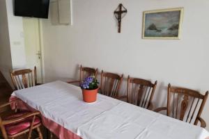 a table with a white table cloth and a flower pot on it at RIBARIĆ in Banjol