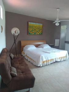 un dormitorio con una cama y un sofá en La Casa del Volcan, en Tlayacapan