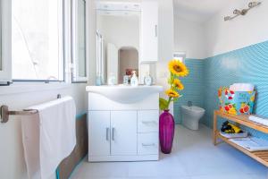a bathroom with a white sink and a purple vase at Casa Dreaming Ortigia in Siracusa