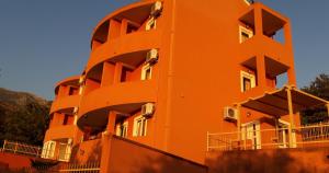 an orange building with balconies on the side of it at Apartments Danilo Kažanegra in Sveti Stefan