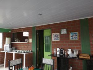 a kitchen with a green door and a brick wall at Pousada Monte Serrat in Bonito