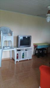 sala de estar con TV, silla y mesa en Aluguel Casa em Praia Seca, en Río de Janeiro