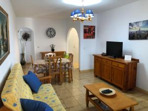 sala de estar con sofá, TV y mesa en Lanzarote - El Golfo, en El Golfo