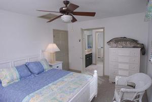 una camera con letto e ventilatore a soffitto di Castaway Cove by Grand Cayman Villas a North Side