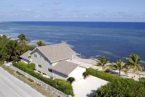 a house on the side of a road next to the ocean at Castaway Cove by Grand Cayman Villas in North Side