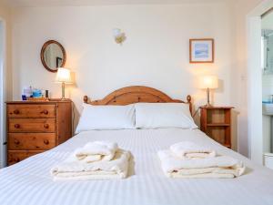 a bedroom with a bed with towels on it at Sunrise, 8 Melbury in Salcombe