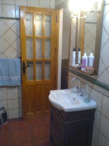a bathroom with a sink and a wooden door at Casa Amat in Rubite