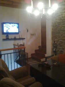a living room with a tv and a couch and stairs at Casa Amat in Rubite