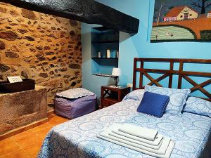 a bedroom with a bed and a stone wall at La Casa del Marqués in Logrosán +79 photos