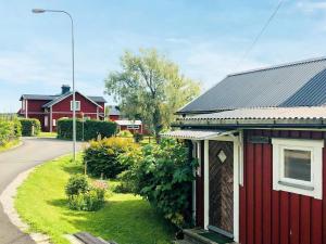 a small red house with a garden next to a street at 4 person holiday home in NORRSUNDET in Norrsundet