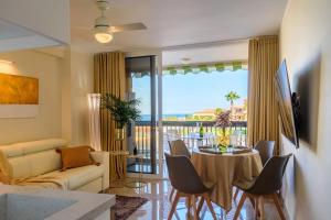 a living room with a couch and a table with chairs at Tenerife Costa Adeje Apartment in Playa Fañabe