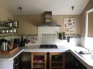 a kitchen with a sink and a stove top oven at De Morgenstond in Baarle-Hertog