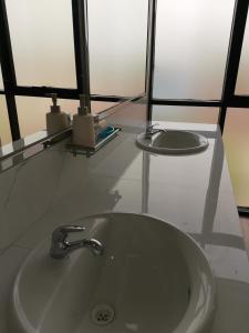 ein Bad mit einem Waschbecken und 2 Spiegeln in der Unterkunft Murano Hotel in Moyobamba