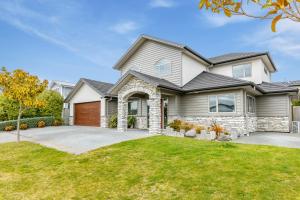 a house with a driveway and grass at Rise and Shine - Taupo in Taupo