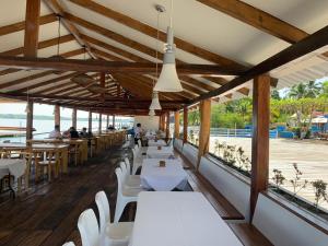 un restaurante con mesas blancas y sillas blancas en Hotel Bahia del Sol, en La Herradura