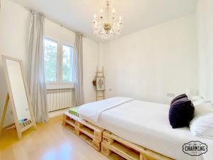 Un dormitorio con una cama grande y una lámpara de araña. en Charming Retiro Exclusive, en Madrid