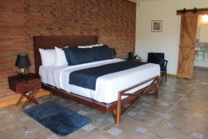 a bed with a white bedspread and a wooden headboard at OJO AZUL RESORT in Valle de Guadalupe