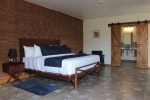 a bedroom with a bed and a brick wall at OJO AZUL RESORT in Valle de Guadalupe