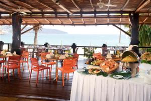 a dining area with tables, chairs and umbrellas at HS HOTSSON Smart Acapulco in Acapulco