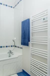 a bathroom with a white tub and a sink at Le Victoria hyper-centre Décines in Décines-Charpieu