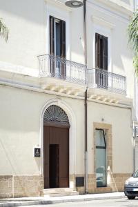 a large white building with a brown door at IL TRULLO Modern Rooms in Brindisi