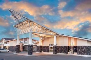 a building with a large structure with a cloudy sky at Siding 16 Lodge in Wetaskiwin