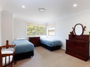 a bedroom with two beds and a mirror and a window at 25 Christmas Bush Avenue aircon pet friendly small boat parking and WI FI in Nelson Bay