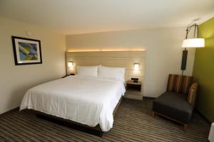 una camera d'albergo con un grande letto e una sedia di Holiday Inn Express Hillsboro I-35, an IHG Hotel a Hillsboro