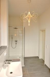 a bathroom with a shower and a sink and a chandelier at Hausdeich in Hamburg