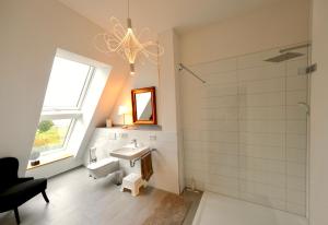 ein Bad mit einem Waschbecken und einer Dusche in der Unterkunft Hausdeich in Hamburg