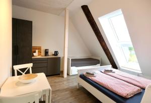 ein kleines Schlafzimmer mit einem Bett und einem Tisch in der Unterkunft Hausdeich in Hamburg