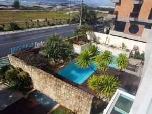an aerial view of a swimming pool with palm trees at Mandai Apartamentos in Cabo Frio