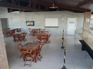 an empty restaurant with wooden tables and chairs at Flat Pipa's Bay in Pipa