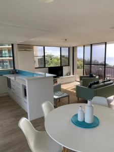a kitchen and living room with a white table and chairs at Pinnacle 701 in Forster