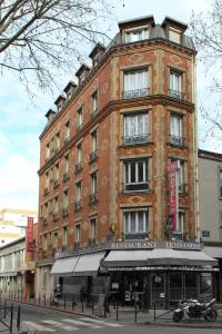 a large brick building on a city street at Hôtel De France in Boulogne-Billancourt