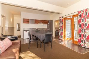a kitchen and living room with a table and chairs at Naseby Apartments in Naseby