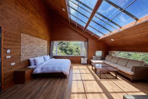 a bedroom with a bed and a couch and windows at Yun Xiang Villa 未接待12歲以下孩童 in Ren'ai