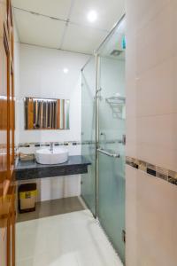 a bathroom with a glass shower and a sink at Golden Hotel in Vung Tau