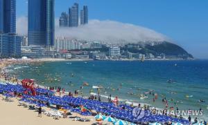 a beach with a bunch of people in the water at Hotel Hyggelig in Busan