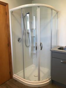 a shower with a glass enclosure in a bathroom at Arches on Bendrose in Twizel