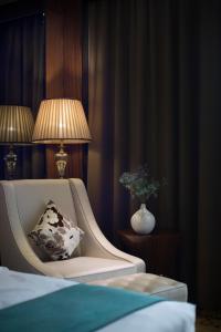 een slaapkamer met een stoel met een kussen en een lamp bij Honder International Hotel in Guangzhou