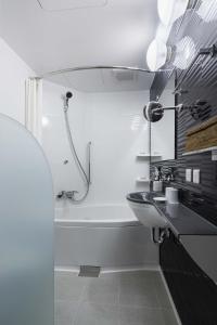 a bathroom with a sink, toilet and shower at KOKO HOTEL Ginza-1chome in Tokyo