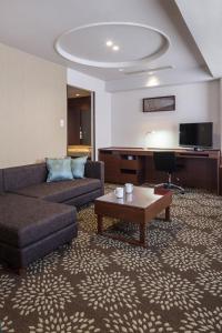 a living room with a couch and a table at ANA Holiday Inn Kanazawa Sky by IHG in Kanazawa
