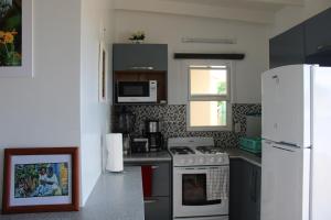 uma cozinha com um fogão branco e um frigorífico em Tropical Garden Cottage Antigua em São João